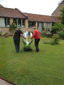 Two large blokes pushing a plastic swan!